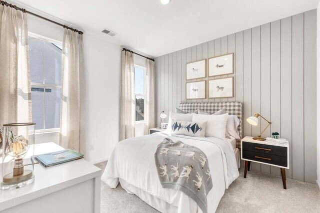 bedroom featuring light carpet and wood walls