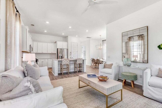 living room featuring ceiling fan, light hardwood / wood-style floors, and sink