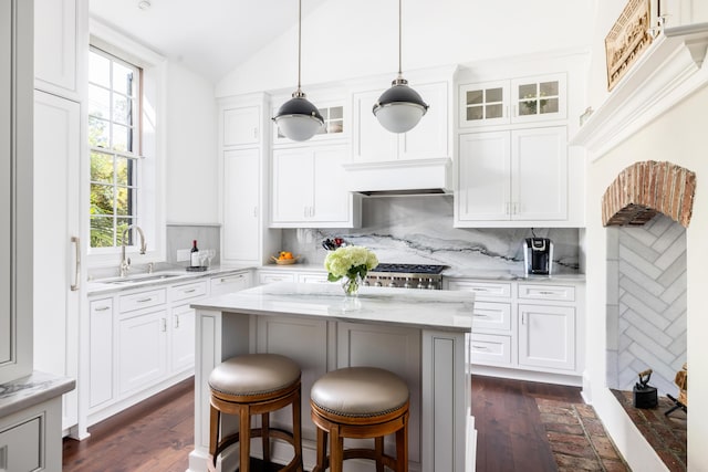 kitchen with backsplash, white cabinetry, and sink