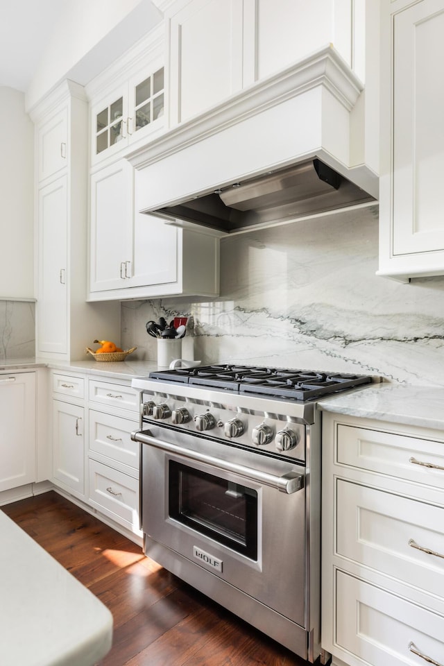 kitchen featuring white cabinets, custom range hood, dark wood-type flooring, and stainless steel stove