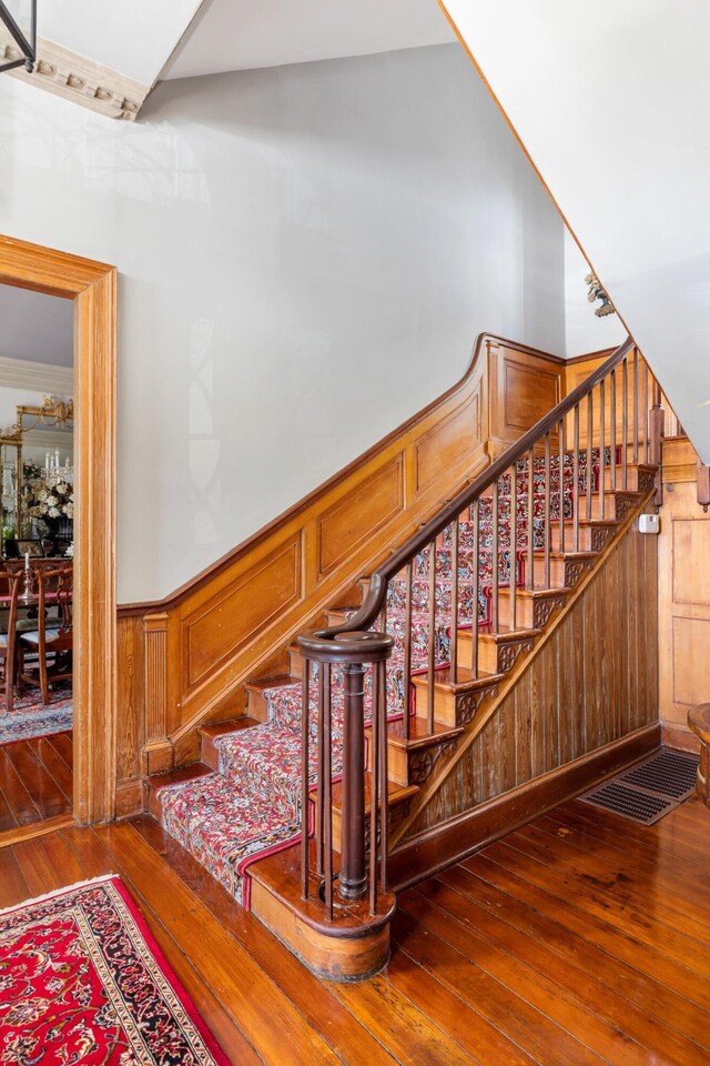 stairway with wood walls and wood-type flooring