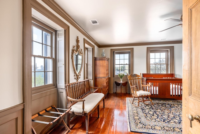 living area with ceiling fan, hardwood / wood-style floors, and ornamental molding