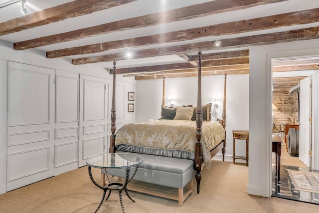 bedroom with beam ceiling and light colored carpet