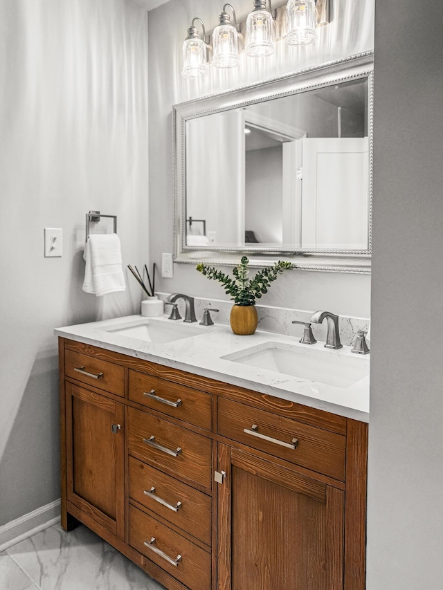 bathroom featuring a sink, baseboards, marble finish floor, and double vanity