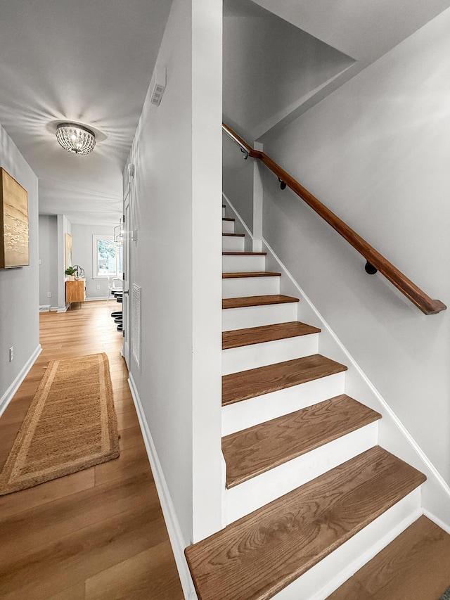 staircase with baseboards and wood finished floors