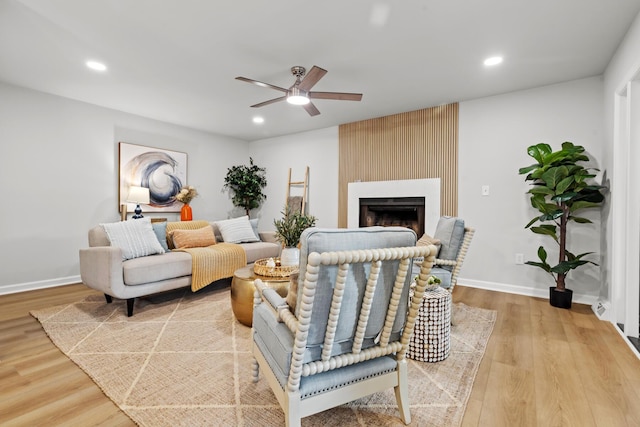 living room featuring recessed lighting, wood finished floors, ceiling fan, and a fireplace