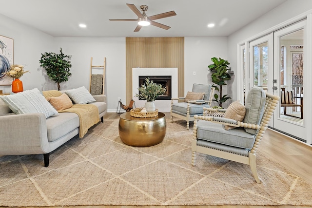 living area with wood finished floors, recessed lighting, french doors, a fireplace, and ceiling fan