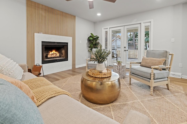 sitting room featuring wood finished floors, baseboards, a fireplace, recessed lighting, and ceiling fan