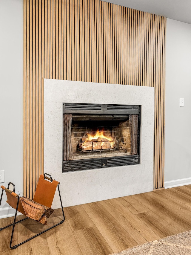 room details with a lit fireplace and wood finished floors