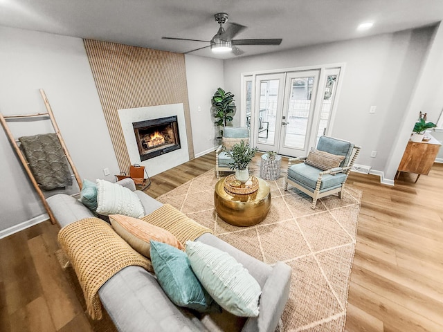 living room featuring wood finished floors, baseboards, french doors, and ceiling fan