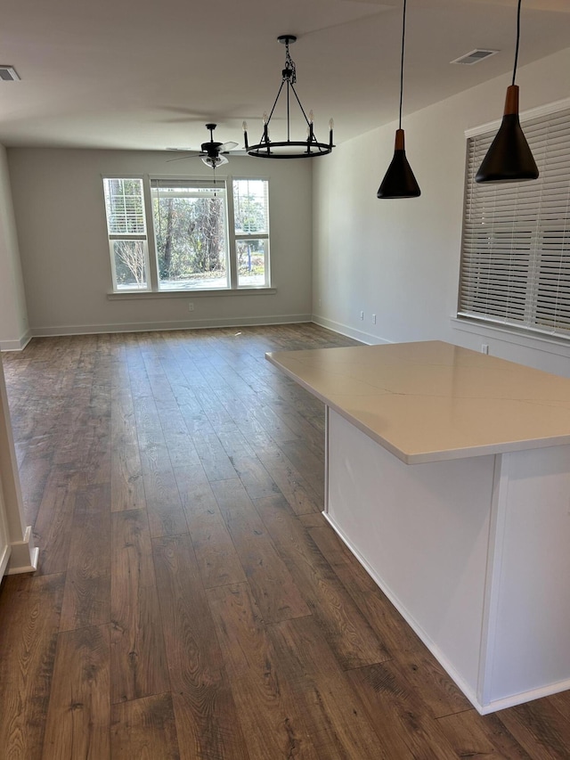 unfurnished dining area featuring dark wood-type flooring and ceiling fan