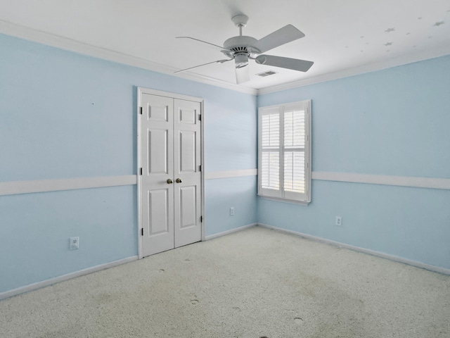 unfurnished room featuring ceiling fan, crown molding, and light carpet