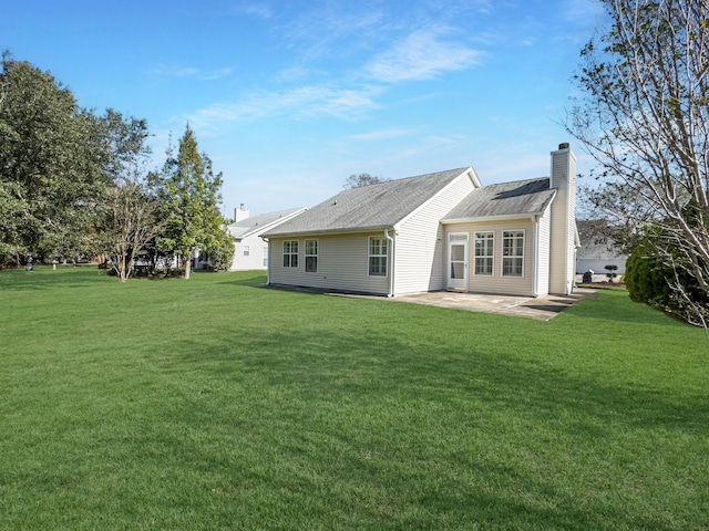 rear view of house featuring a yard and a patio