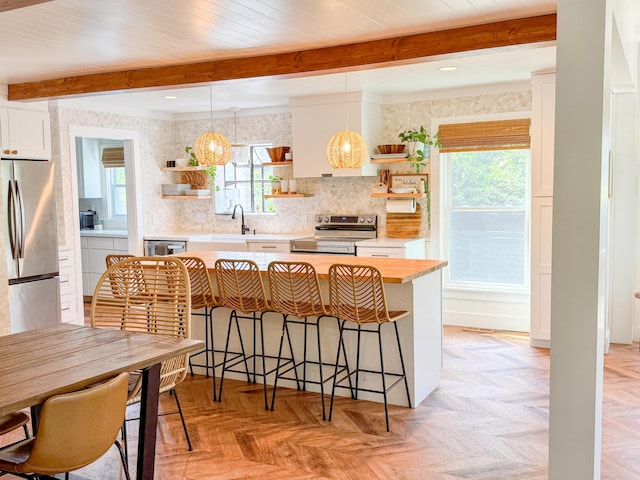 27 Fitzroy Dr, Charleston, SC 29414 - kitchen featuring open shelves, appliances with stainless steel finishes, beamed ceiling, a sink, and a kitchen breakfast bar