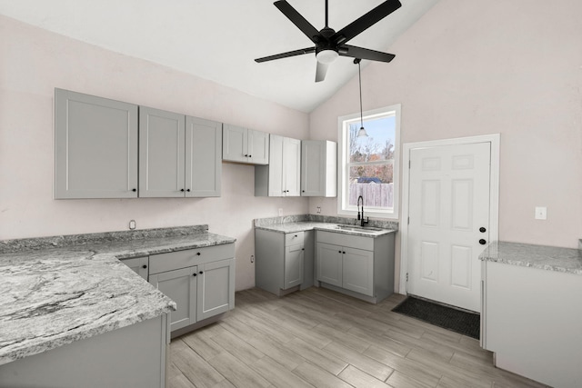 kitchen featuring gray cabinetry, ceiling fan, sink, and vaulted ceiling