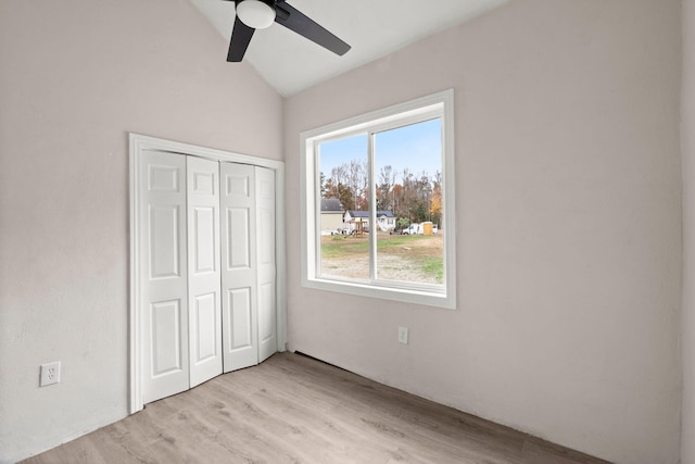 unfurnished bedroom with ceiling fan, vaulted ceiling, light hardwood / wood-style flooring, and a closet