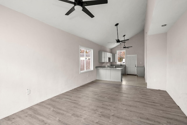 unfurnished living room featuring ceiling fan, light hardwood / wood-style floors, and lofted ceiling