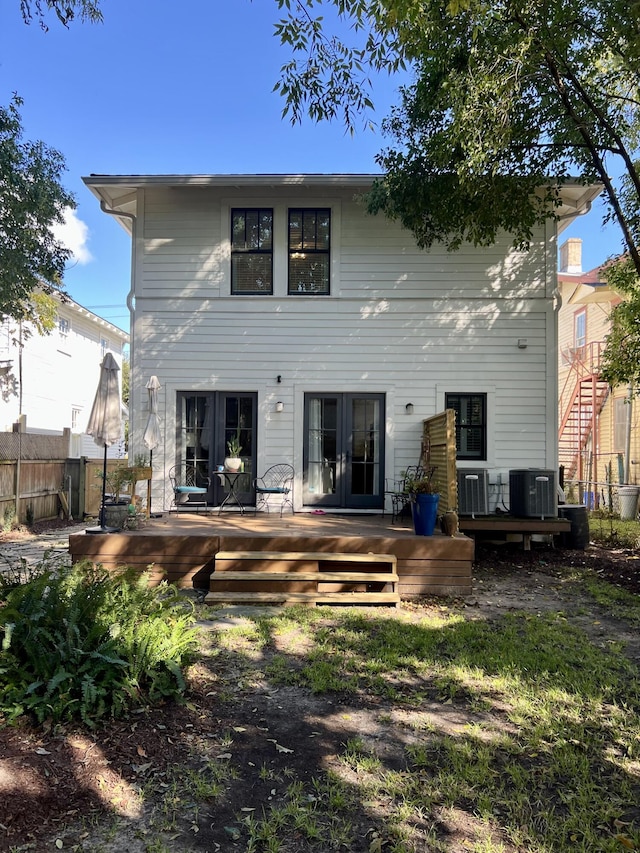 rear view of property with french doors, cooling unit, and a deck