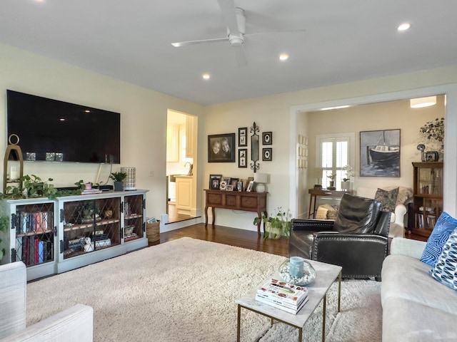 living room featuring ceiling fan and dark hardwood / wood-style floors