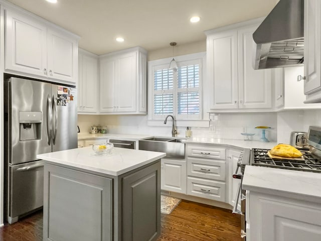 kitchen with stainless steel appliances, white cabinetry, sink, and extractor fan