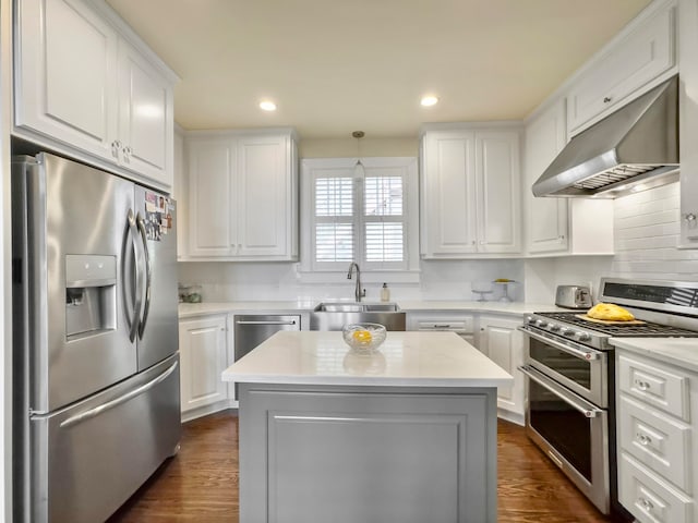 kitchen with appliances with stainless steel finishes, a kitchen island, sink, and white cabinets