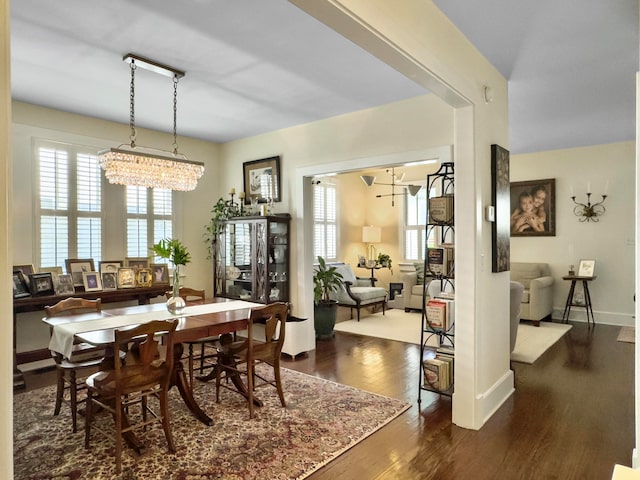 dining area featuring dark wood-type flooring and a chandelier