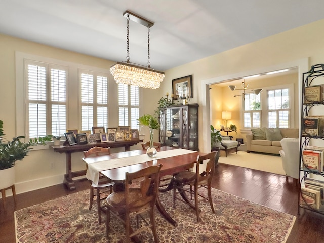 dining area featuring an inviting chandelier, dark hardwood / wood-style flooring, and plenty of natural light