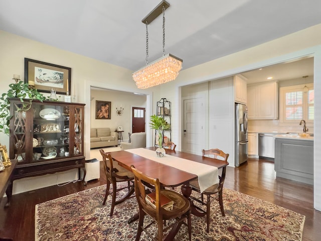 dining area featuring a notable chandelier, dark hardwood / wood-style floors, and sink