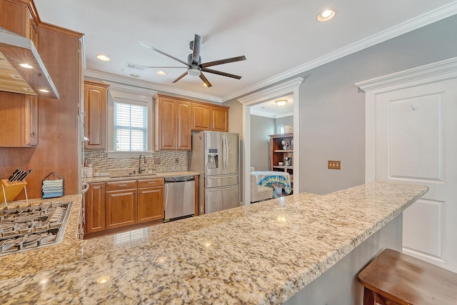 kitchen with stainless steel appliances, a ceiling fan, a sink, under cabinet range hood, and light stone countertops