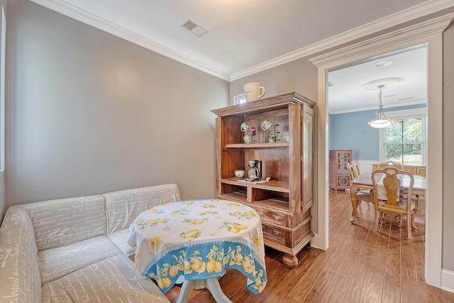 living area featuring wood finished floors and crown molding