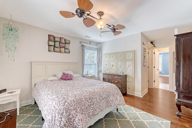 bedroom with wood finished floors, baseboards, and a ceiling fan