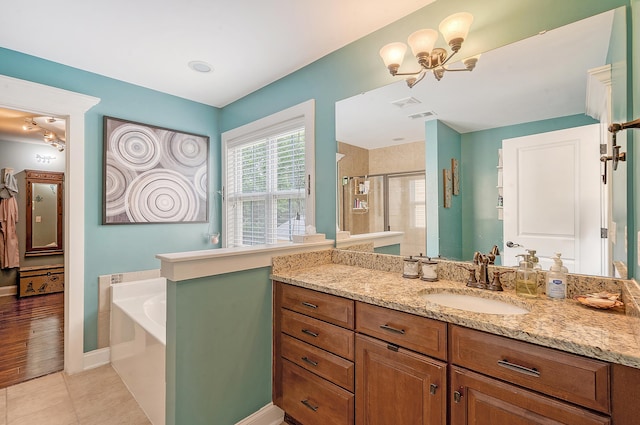 full bath featuring a shower stall, tile patterned floors, a garden tub, vanity, and baseboards