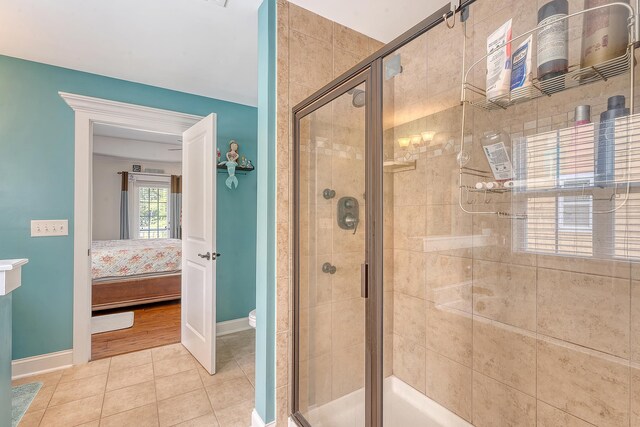 ensuite bathroom featuring a shower stall and baseboards