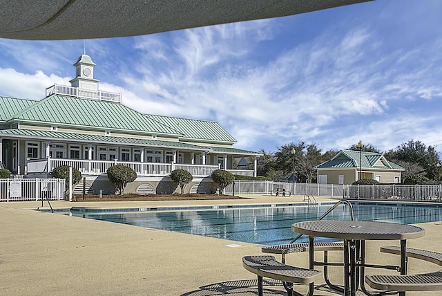 community pool with fence and a patio area
