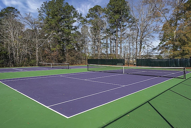 view of tennis court featuring fence and community basketball court