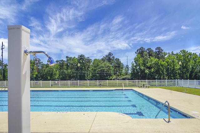 community pool with fence and a patio area