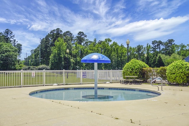 community pool featuring fence and a patio area