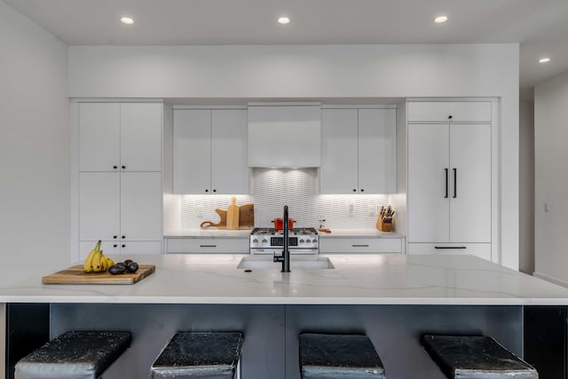 405 Spartina Ln Unit 405, Charleston, SC 29492 - kitchen with a sink, modern cabinets, a kitchen bar, white cabinetry, and backsplash