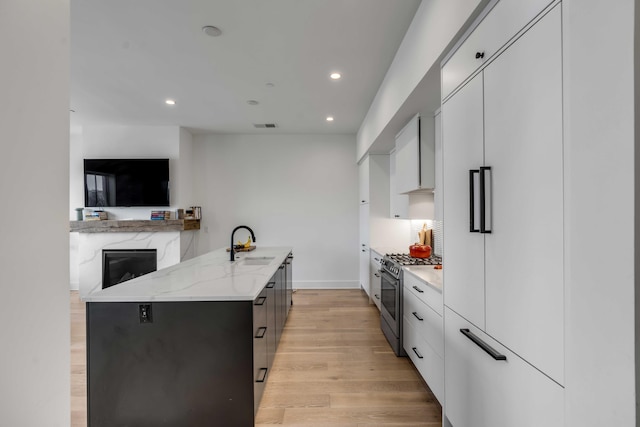 405 Spartina Ln Unit 405, Charleston, SC 29492 - kitchen featuring stainless steel range with gas cooktop, modern cabinets, paneled refrigerator, a sink, and light stone countertops
