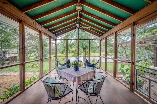 sunroom / solarium featuring vaulted ceiling with beams, a healthy amount of sunlight, and ceiling fan