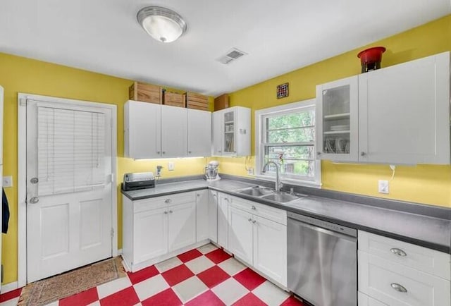 kitchen with white cabinets, tile patterned floors, dishwasher, and a sink