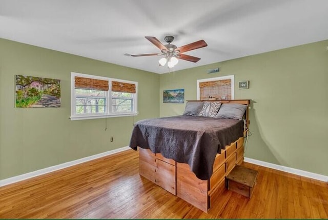 bedroom with wood finished floors, baseboards, and ceiling fan