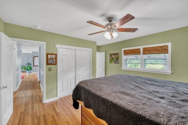 bedroom with ceiling fan, a closet, and light hardwood / wood-style floors