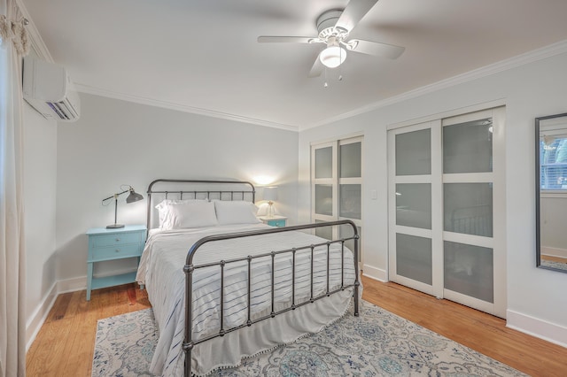 bedroom featuring a wall mounted air conditioner, light wood-type flooring, ceiling fan, and ornamental molding