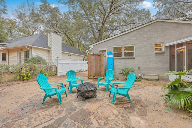 view of patio / terrace featuring a sunroom and a fire pit