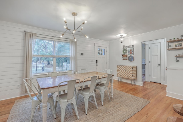 dining area featuring wood walls, light hardwood / wood-style flooring, plenty of natural light, and an inviting chandelier