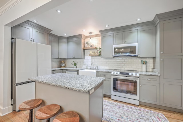 kitchen with backsplash, light stone counters, white appliances, and sink