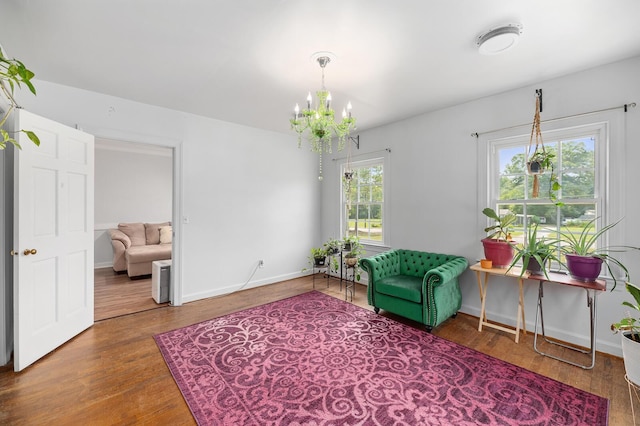 sitting room with wood-type flooring and an inviting chandelier