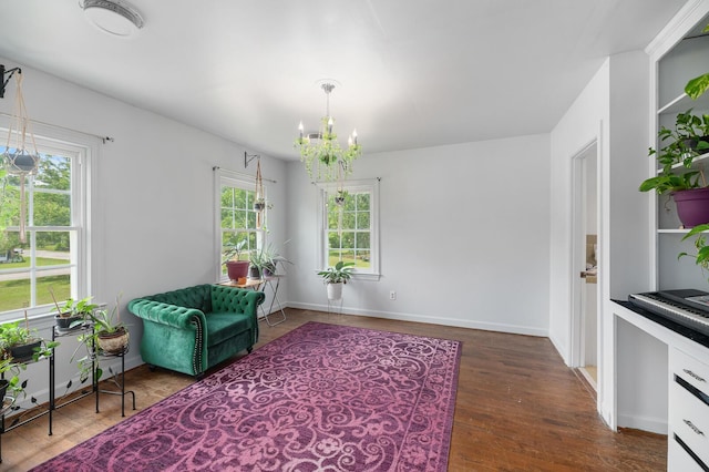 sitting room with dark wood-type flooring and a chandelier