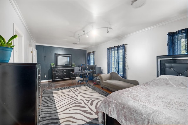 bedroom with dark wood-type flooring, ornamental molding, and track lighting